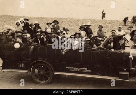 Leute in einem Charaban am Meer -- das Fahrzeug wurde von Autocar Services Limited, Opera House Buildings, Tunbridge Wells, Kent gemietet. Stockfoto