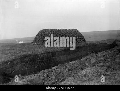 Torfstapel in der Grafschaft Donegal, Nordwesten Irlands, mit einem Graben im Vordergrund, aus dem der Torf gegraben wurde. Stockfoto