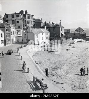 Eine von vielen Studien über St. Ives, Cornwall. Das Ende der Wharf & Quay Street. Dreirädriger Wagen. Harbour Beach Foresand, Cottages & Quay House, St Leonard's Chapel, das Pilot's Office (jetzt das Harbour Master's Office), Punts am Strand und Wäschetrockner. Am Strand waren nur wenige Leute und es gab zwei Liegestühle. Stockfoto