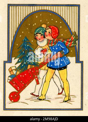 Weihnachtskarte, zwei Mädchen schieben einen Weihnachtsbaum und Spielzeug in einer roten Schubkarre im Schnee. Stockfoto