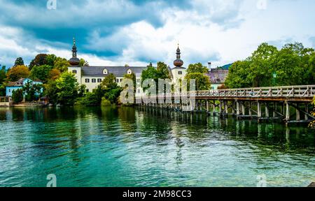 Sonnenschein Holzbrücke über den See mit türkisfarbenem Wasser in Hallstatt, Österreich Stockfoto