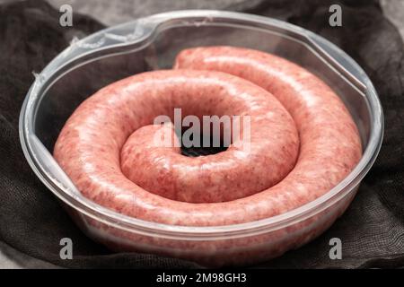 Gerolltes Botifarra, eine für Katalonien typische Schweinefleischwurst, in einem Plastik Stockfoto