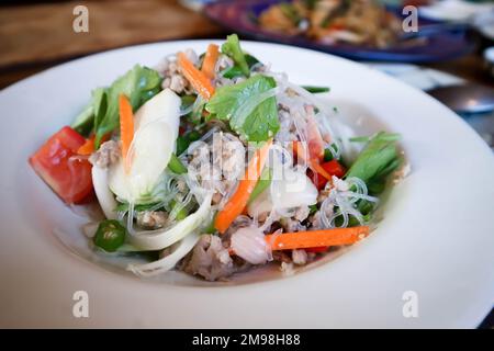 Würziger Salat oder Nudelsalat, thailändischer würziger Salat oder Vermicelli und Hackporksalat oder Vermicelli-Salat zum Servieren Stockfoto