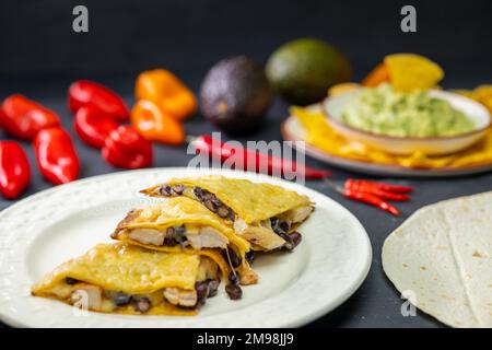 Quesadilla mit Hühnerfleisch und Bohnen und Guacamole mit Nachos Stockfoto