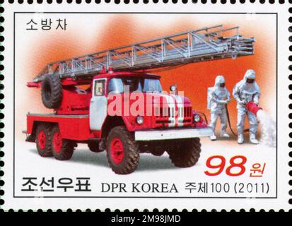 2011 Nordkorea Briefmarke mit einem Feuerwehrwagen ZIL-131 AL-30 und Feuerwehrleuten in Schutzausrüstung. Stockfoto