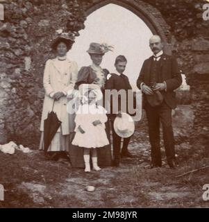 Familie (Arthur, Harold, Lucy, Ellen und Violet Auerbach) auf einem Urlaubsausflug in das Dorf Dunwich, Suffolk, August 1908. Das Gebäude dahinter ist die Allerheiligen-Kirche, verlassen in den 1750er Jahren. Zu dieser Zeit bedeutete die Erosion an der Küste, dass sich das Gebäude an der Klippe befand: Der Turm fiel 1922. Stockfoto