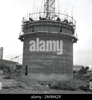 1950er, historischer, runder Betonturm, der mit Stahlstangen verstärkt wird, wird in der Abbey Works Stahlwalzwerke in Port Talbot, South Wales, Großbritannien, gebaut, der Heimat der Steel Company of Wales (Scow). Die Verwendung von Stahlstangen mit Beton verleiht der zu bauenden Struktur mehr Festigkeit und Flexibilität als nur Beton. Der Standort Port Talbot in Südwales würde im Laufe des Jahrzehnts erweitert und in den 1960er Jahren zum größten Stahlkomplex in Europa werden. Stockfoto