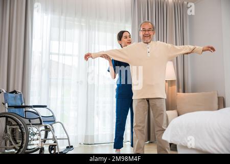 Der alte Senior-Mann trainiert zu Hause gern mit einem Physiotherapeuten für ausgestreckte Arme Stockfoto