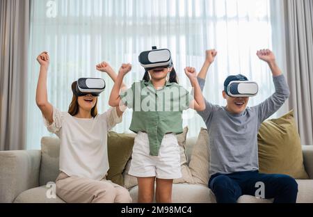 Asiatische Familienbekleidung mit Brille, Kopfhörer auf dem Sofa im Wohnzimmer Stockfoto