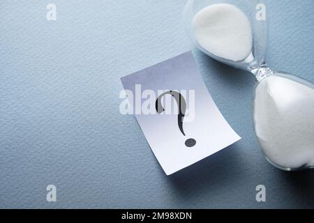 Das Konzept des Zeitmanagements, dargestellt mit einer Sanduhr, Sanduhr neben einem Fragezeichen Stockfoto