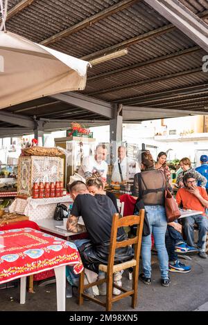 Florenz, Italien - 15. April 2022: Gäste essen beim Verkäufer auf dem Sant'Ambrogio Markt, Mercato di Sant'Ambrogio, Piazza Lorenzo Ghiberti Stockfoto