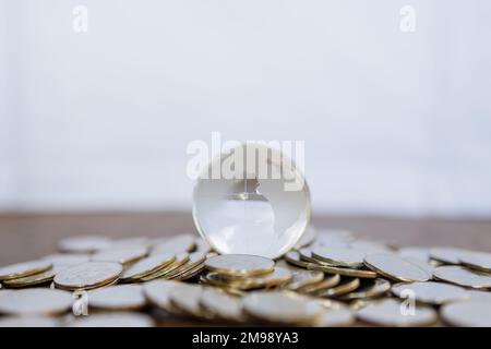 Global Business and Financial, Economic and Palnning Concept. Nahaufnahme eines durchsichtigen Mini World Balls aus Glas auf einem Haufen Münzen mit Kopierraum. Stockfoto