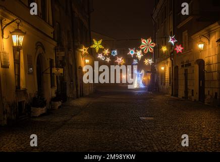 Nachtsicht auf die bunten Straßen der Stadt bei dichtem Nebel und Smog. Wintersaison, Weihnachtszeit mit bunten Lichtern auf den Straßen. Stockfoto