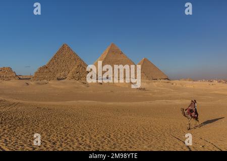 KAIRO, ÄGYPTEN - 28. JANUAR 2019: Kamelreiter vor den Großen Pyramiden von Gizeh, Ägypten Stockfoto