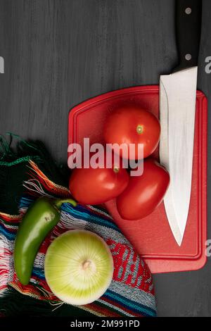 Zutaten für die Zubereitung einer Soße, mit einem Schneidebrett und einem Messer Stockfoto