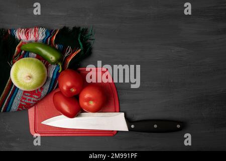 Zutaten für die Zubereitung einer Soße, mit einem Schneidebrett und einem Messer Stockfoto