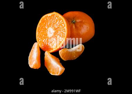 Studiofoto einer halbierten Orange mit drei orangefarbenen Wedges. Stockfoto