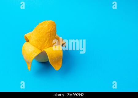 Geschälte Mango mit blauem Hintergrund und Kopierbereich Stockfoto