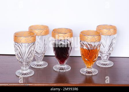 Getränk, Set Mit Fünf Goldfarbenen Glasbechern; Foto Auf Holzhintergrund. Stockfoto