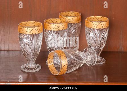 Getränk, Set Mit Fünf Goldfarbenen Glasbechern; Foto Auf Holzhintergrund. Stockfoto