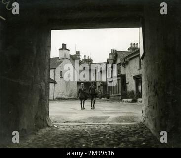 Straßenszene in der Marktstadt Hawkshead, Cumbria, Oktober 1933, mit Jungen, die von der Schule nach Hause kommen. Stockfoto