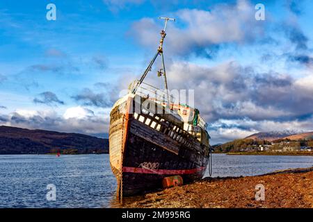 Old Boat of Caol Fort William Scotland blauer Himmel das Boot liegt im Winter am Strand Stockfoto