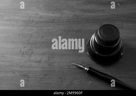 Füllfederhalter mit Tinte auf grauem Holzboden, mit Platz für Kopien Stockfoto