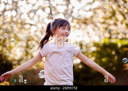 Smiling Girl Im Freien Mit Bubbles Im Garten Stockfoto