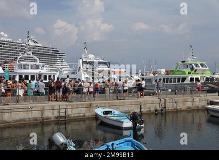 Touristen auf einem Ausflug nach Ajaccio kehren zurück zum Schiff mit MSC Seaside Kreuzfahrtschiff im Hintergrund, Hafen von Ajaccio, Insel Korsika, Frankreich Stockfoto