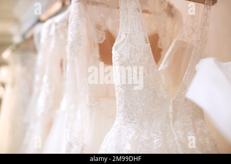 Nahaufnahme Der Wunderschönen Hochzeitskleider, Die Im Laden An Der Schiene Hängen Stockfoto