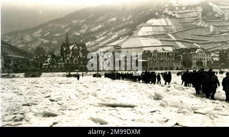 Britische Truppen überquerten den gefrorenen Rhein in Deutschland, mit Weinbergen in der Ferne, nach dem Ende des Ersten Weltkriegs. Stockfoto