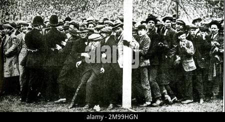 Die Menge wird beim FA-Cup-Finale zwischen West Ham United und Bolton Wanderers in Wembley am 28. April 1923 zurückgehalten. Es gab so viele Zuschauer, dass sie auf das Spielfeld geschleudert wurden, wodurch der Start des Spiels um 45 Minuten verzögert wurde. Stockfoto