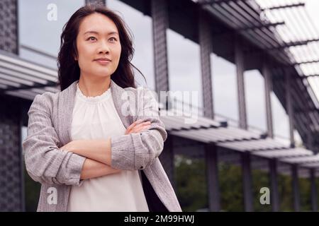 Porträt Einer Lächelnden Geschäftsfrau, Die Vor Dem Modernen Bürogebäude Steht Stockfoto