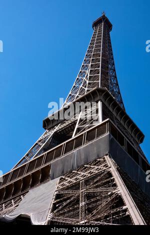 Blick auf den Eiffelturm, Paris, Frankreich. Der ikonische Turm ist von der Basis aus zu sehen und blickt auf die Spitze des Turms vor einem blauen Himmel Stockfoto