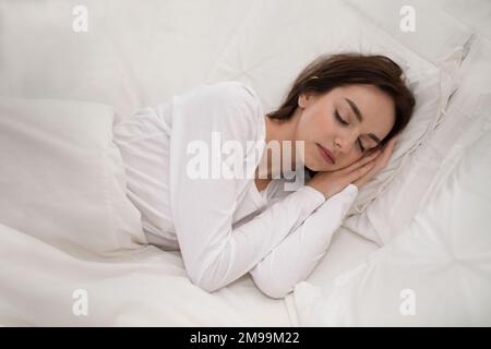 Schöne junge Frau, die zu Hause im Bett ruht Stockfoto