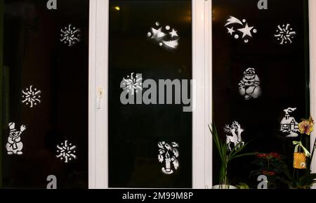 Dekoriertes Fenster für Weihnachten und Neujahr mit Figuren aus künstlichem Schnee. Stockfoto