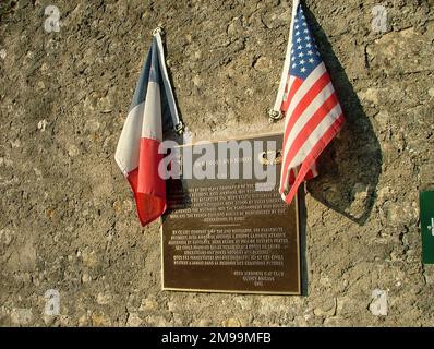 Die Plakette wurde vom 82. Airborne C47 Club errichtet und erinnert an die Aktion der „Kompanie D“ des 2. Bataillons 505 Parachute Infanterie Regiment, 82. Airborne Division, die einen deutschen Angriff auf Ste Mere Eglise vereitelte. Er würdigt auch die Hilfe der Franzosen bei der Versorgung der Verwundeten. Nach der Normandie trugen die 505. Schulterabzeichen den Text "H-MINUS" unten, weil das Bataillon früher gesprungen ist, als es hätte tun sollen. Stockfoto