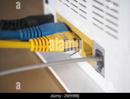 Anschließen der Kabel an das Modem. Internet-Sharing, Verwirrungshintergrund. Stockfoto