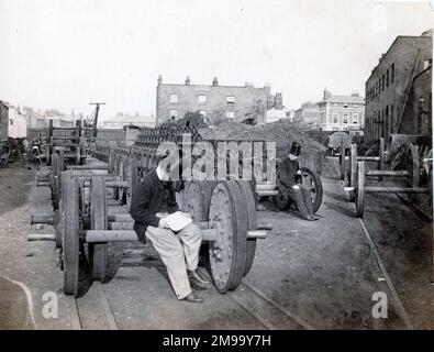 Ein Blick entlang der Nordseite der Locomotive der Great Eastern Railway arbeitet in Stratford (East London) am 1864. Mai mit William Henry Maw, dem damaligen Leiter des Zeichnungsbüros, der auf der Achse eines Wagens sitzt, und seinem Kollegen James Kitson weiter hinten. Im Hintergrund befinden sich das Railway Tavern Public House (das noch vorhanden ist) und die Wohnungen im Bereich Angel Place. Stockfoto