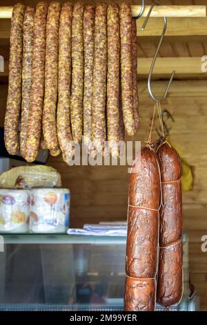 Würstchen und andere Fleischspezialitäten in verschiedenen Farben und Größen werden auf der Theke gestapelt. Fairer Handel mit hausgemachten Fleischspezialitäten. Nahaufnahme. Sele Stockfoto