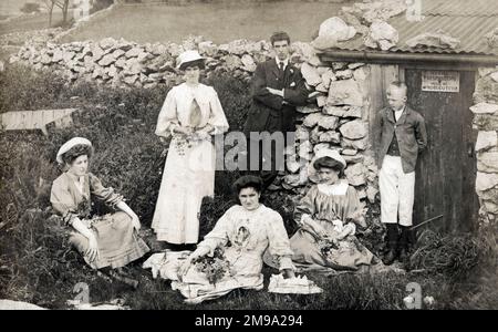 Eine Gruppe von Teenagern und jungen Erwachsenen erschaffen ein „ländliches tableau“ in der Nähe einer alten Steinscheune. Stockfoto