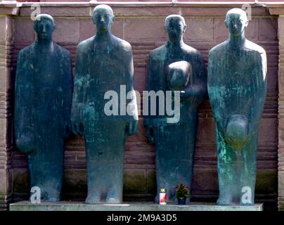 Bei verschiedenen Renovierungen im Laufe der Jahre wurden diese Zahlen von Ort zu Ort auf dem Friedhof verlegt. Jetzt stehen sie am oberen Ende des Massengrabes. Sie wurden von Professor Emil Krieger geformt. Stockfoto