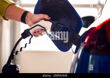 Nahaufnahme Der Handbefestigung Des Ladekabels An Einem Umweltfreundlichen Emissionsfreien Elektrofahrzeug Stockfoto