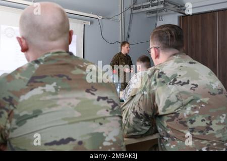 Richard Laikos, lettischer Landwehrkapitän, der der Planungsabteilung der lettischen mechanisierten Infanteriebrigade zugeteilt ist, geht mit den Befehlshabern der beteiligten Feuerwehrteams am Vorruhestandort Adazi, Lettland, am 15. Mai 2022 die Einsatzübersicht für Übung Summer Shield 22 durch. Summer Shield ist einer von den USA Die multinationalen Ausbildungsübungen der Armee Europa und Afrikas in Osteuropa, die Defender Europe 22 bilden. Defender demonstriert U.S. Die Fähigkeit der Armee Europa und Afrika, großangelegte Bodenkampfoperationen in mehreren Theatern zur Unterstützung der NATO durchzuführen. Stockfoto