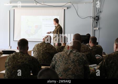 Richard Laikos, der lettischen Raumstreitkräfte zugeteilt in der Planungsabteilung der lettischen mechanisierten Infanteriebrigade, geht mit den Befehlshabern der beteiligten Feuerwehrteams am Vorwärtstreupunkt Adazi, Lettland, am 15. Mai 2022 die Einsatzübersicht für Übung Summer Shield 22 durch. Summer Shield ist einer von den USA Die multinationalen Ausbildungsübungen der Armee Europa und Afrikas in Osteuropa, die Defender Europe 22 bilden. Defender demonstriert U.S. Die Fähigkeit der Armee Europa und Afrika, großangelegte Bodenkampfoperationen in mehreren Theatern zur Unterstützung der NATO durchzuführen. Stockfoto