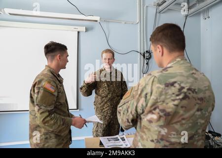 Richard Laikos, Hauptmann der lettischen Landstreitkräfte, der der Planungsabteilung der lettischen mechanisierten Infanteriebrigade zugeteilt wurde, beantwortet Fragen aus den USA Soldaten, die der 1. Infanteriedivision Artillerie nach der Einsatzbesprechung für Übung Summer Shield 22 am vorderen Einsatzort Adazi, Lettland, am 15. Mai 2022 zugeteilt wurden. Summer Shield ist einer von den USA Die multinationalen Ausbildungsübungen der Armee Europa und Afrikas in Osteuropa, die Defender Europe 22 bilden. Defender demonstriert U.S. Die Fähigkeit der Armee Europa und Afrika, großangelegte Bodenkampfoperationen in mehreren Kinos zur Unterstützung der NA durchzuführen Stockfoto