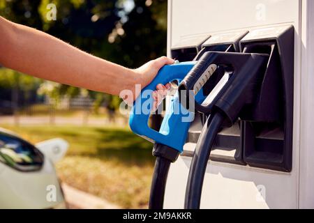 Nahaufnahme Der Hand Mit Der Ladestation Zum Aufladen Des Emissionsfreien Elektroautos Stockfoto