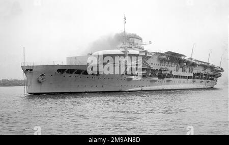 Royal Navy - HMS Glorious, Flugzeugträger, vor Anker, dampfend. HMS Glorious war der zweite von drei mutigen Kampfsportlern, die während des Ersten Weltkriegs für die Royal Navy gebaut wurden. Sie wurden entwickelt, um das baltische Projekt zu unterstützen, das vom ersten Seelord Lord Lord Fisher gefördert wurde, und waren relativ leicht bewaffnet und gepanzert. Glorious wurde Ende 1916 fertiggestellt und hat den Krieg auf Patrouille in der Nordsee verbracht. Sie nahm an der zweiten Schlacht von Helgoland im November 1917 Teil und war anwesend, als die deutsche Hochseeflotte ein Jahr später kapitulierte. Glorious wurde nach dem Krieg bezahlt, Bu Stockfoto