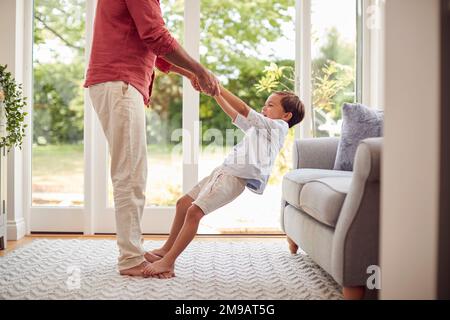 Vater Und Sohn Zu Hause, Die In Der Lounge Das Spiel Gemeinsam Spielen Stockfoto