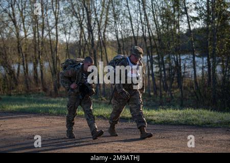 SPC. Michael Wallace aus Springfield, Illinois, Spezialist für Signalunterstützungssysteme, Hauptquartier und Hauptquartier der Illinois National Guard, 2. Bataillon, 130. Infanterie-Regiment und Sergeant Robert Black aus Crystal Lake, Illinois, Am 15. Mai 2022 stürzte sich ein Spezialist für Gesundheitsfürsorge bei der 708. Medical Company der Illinois National Guard während des Wettbewerbs der besten Krieger der Region IV durch den 12-Meilen-Rruck. Er ist einer von zwölf Soldaten der Nationalgarde, die am 11.-15. Mai 2022 im Camp Ripley, Minnesota, am Wettbewerb der besten Krieger der Region IV teilnehmen. Der jährliche Wettkampf testet die Milita Stockfoto